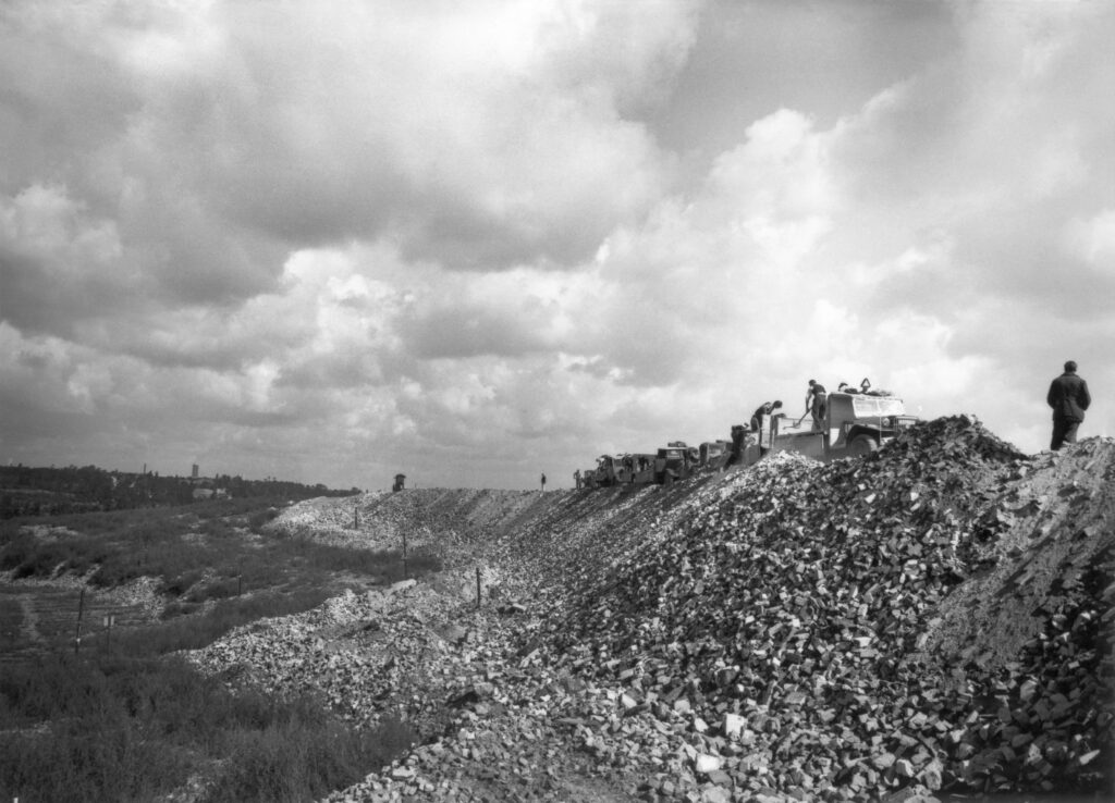 Schwarz-weiß-Foto, das zeigt, wie die Trümmer des im Zweiten Weltkrieg zerstörten Berlins zu einem Berg aufgeschüttet werden.