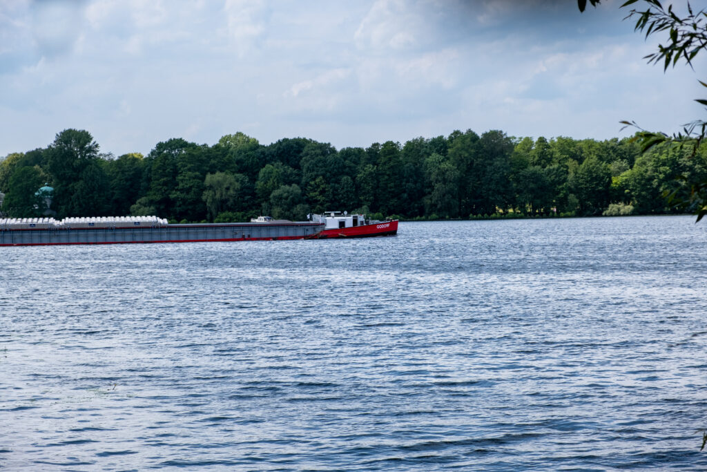 Aussicht vom Ufer auf die Havel, auf der ein Schiff fährt
