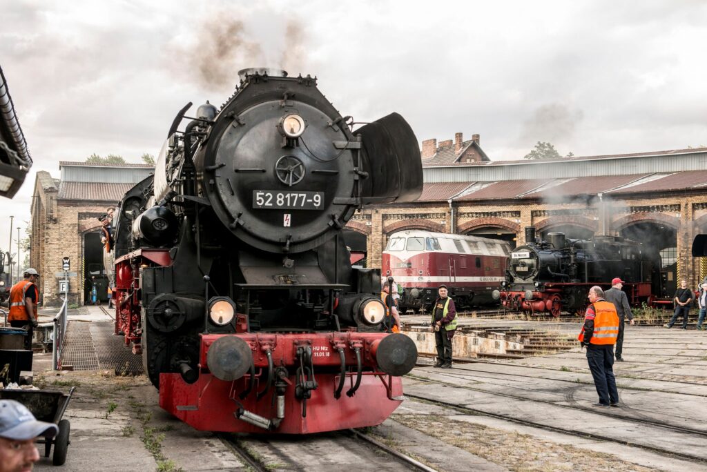 Schwarz-rote Dampflokomotive fährt auf einer Drehscheibe