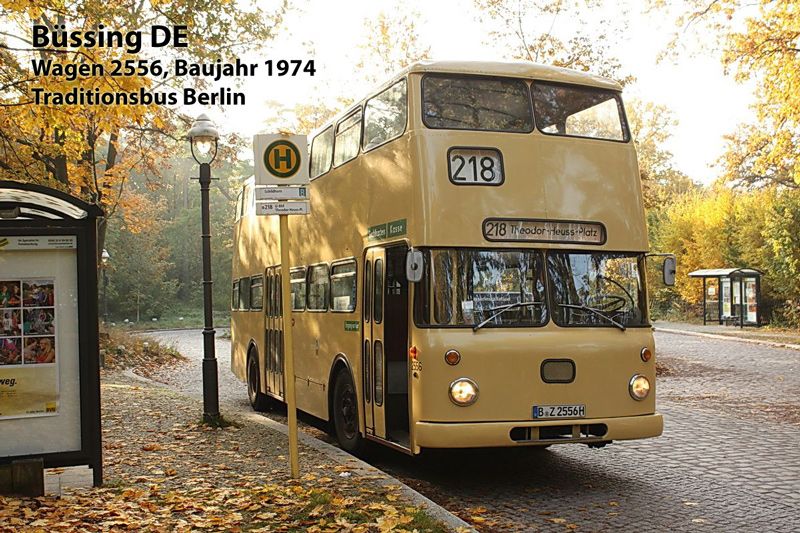 Ein historischer Doppeldeckerbus steht an einer Haltestelle. Auf der Straße liegt Laub.