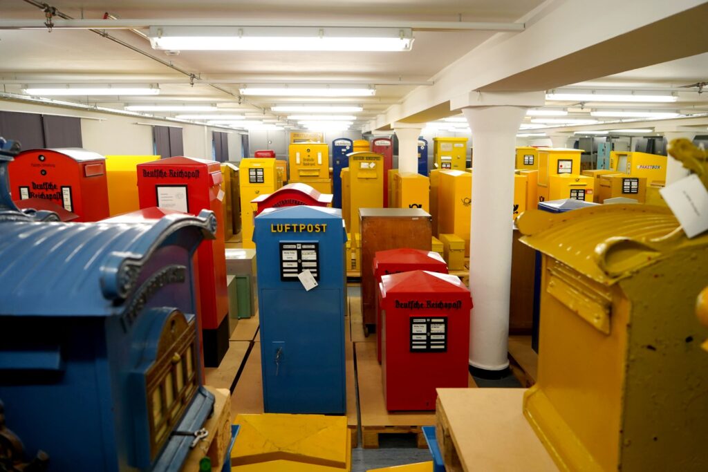 Historische Briefkästen in blau, gelb und rot.