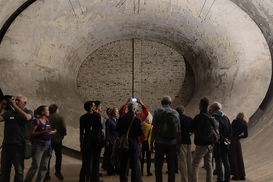 Eine Gruppe Menschen steht während einer Führung im Windkanal und fotografiert.
