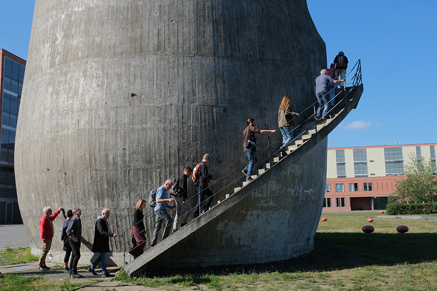 Menschen gehen die Außentreppe am Trudelturm hoch.