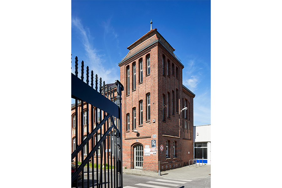 Ein Turm aus rotem Backstein, integriert in die Fassade