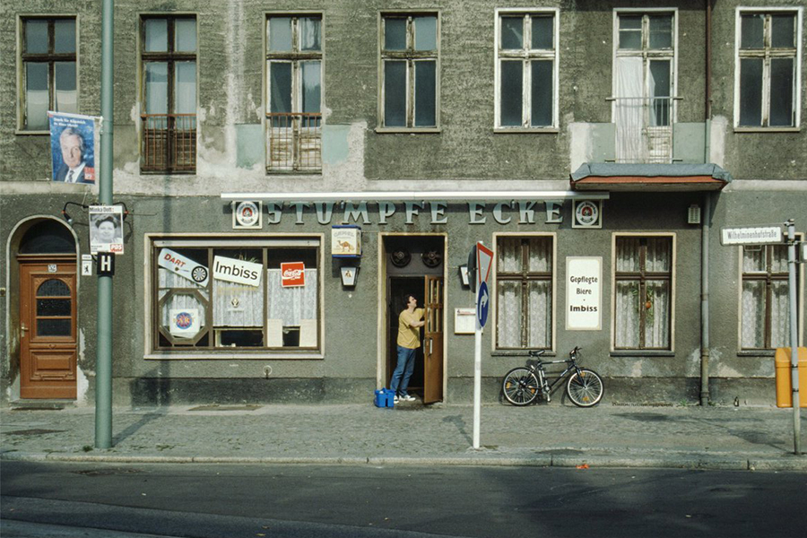 Ein historische Farbfoto aus den 1980er-Jahren. Ein Mann putzt die Febster der Kneipe "Stumpfe Ecke".
