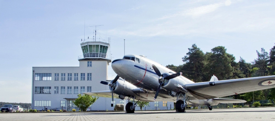 Ein Flugzeug steht vor dem ehemaligen Tower des Flughafens Gatow.