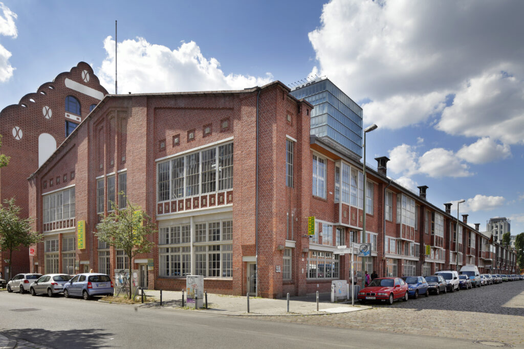 Backsteingebäude an einer Straßenecke in Friedrichshain vor blauem Himmel