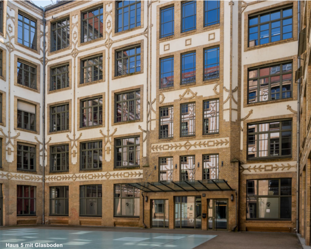 Fassade aus Ziegeln mit gelben und weißen Verzierungen und großen Fenstern