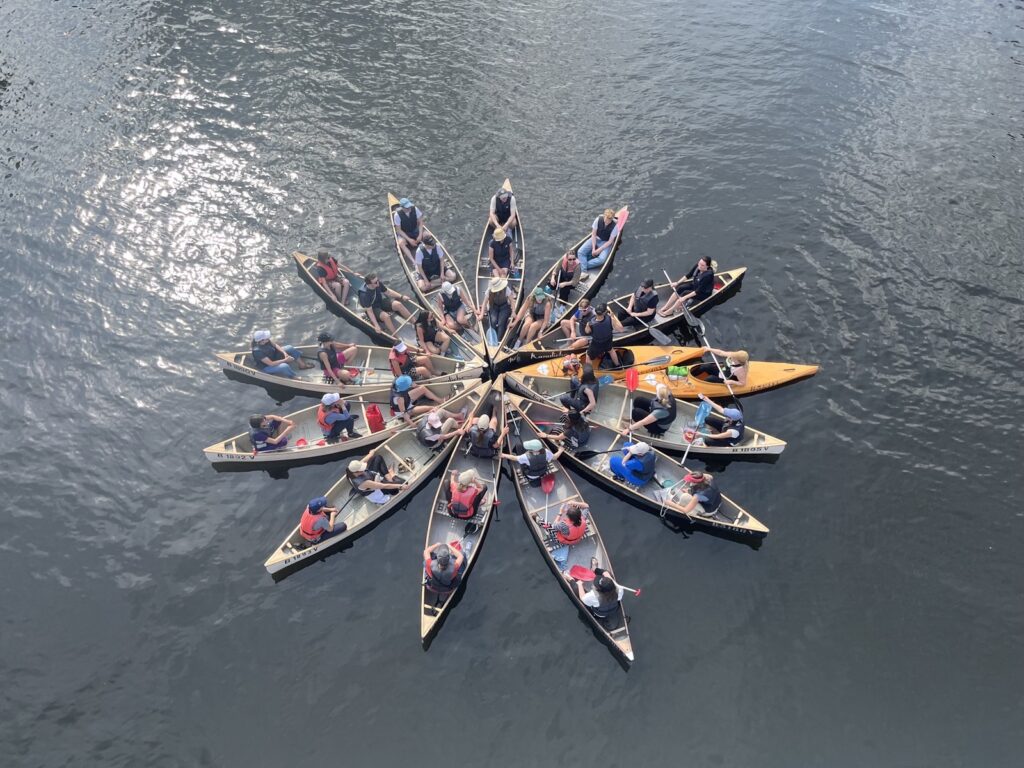 Sternförmige Anordnung von Kanus auf dem Wasser.