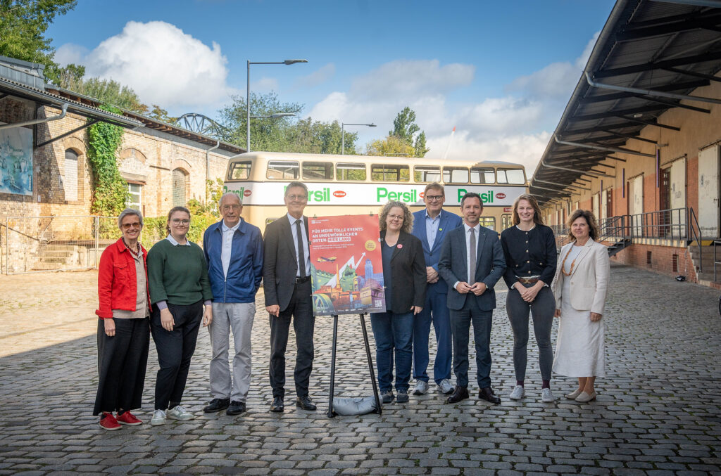 Gruppenbild mit Doppeldecker Bus im Hintergrund