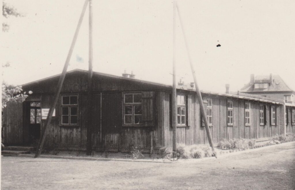 Historisches Foto einer eingeschossigen Baracke aus Holz.