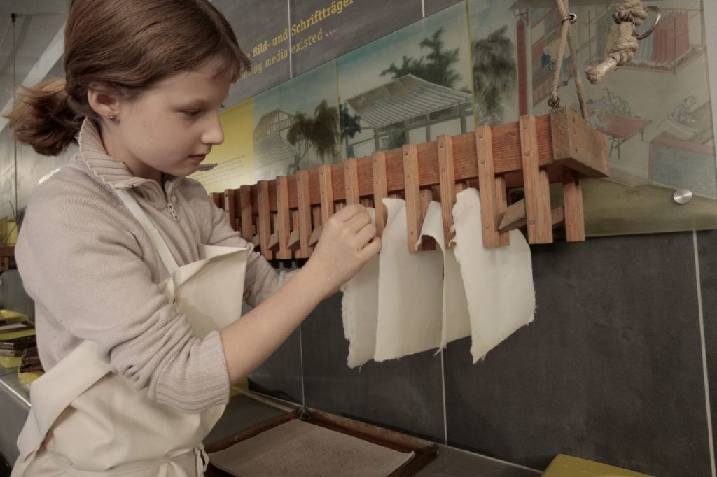 Mädchen beim Papierschöpfen im Technikmuseum Berlin