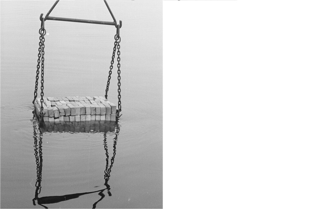 Schwarz-weiß Foto um 1955. Ziegel werden von einem Kran in die Spree herabgelassen und genässt.