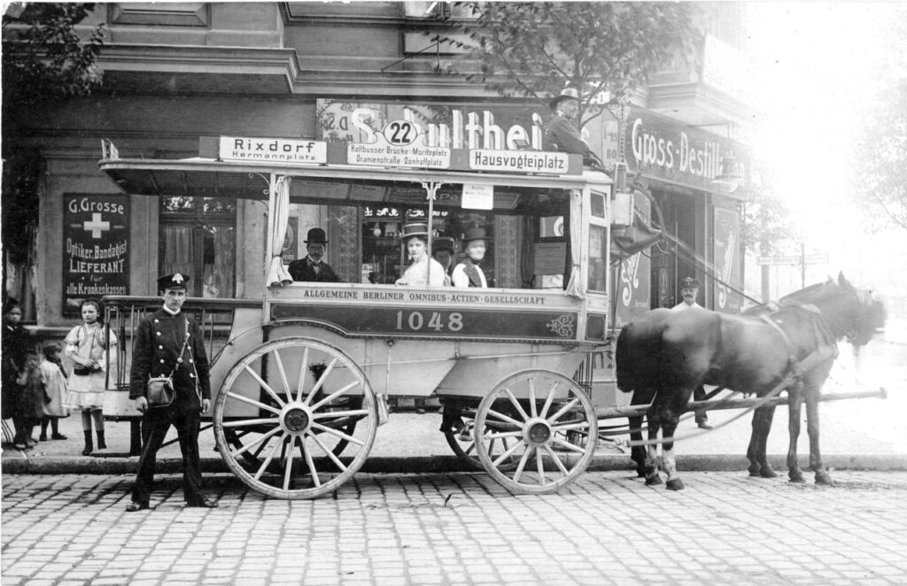 Historischen schwarz-weiß Bild aus dem 19. Jahrhundert. Zu sehen ist eine Pferdekutsche mit Passagieren und Kontrolleur.