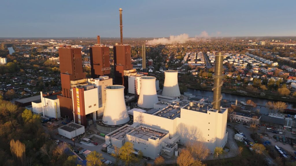 Luftbild der gesamten Anlage des Heizkraftwerks Lichterfelde. Im Hintergrund breitet sich die Stadt aus.