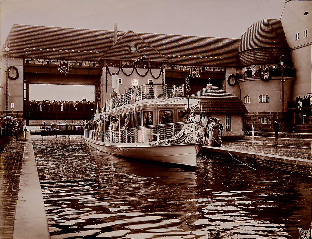 Eine historische Fotografie von 1906. Sie zeigt ein Boot an der Schleuse Kleinmachnow bei der Eröffnung des Teltowkanals.