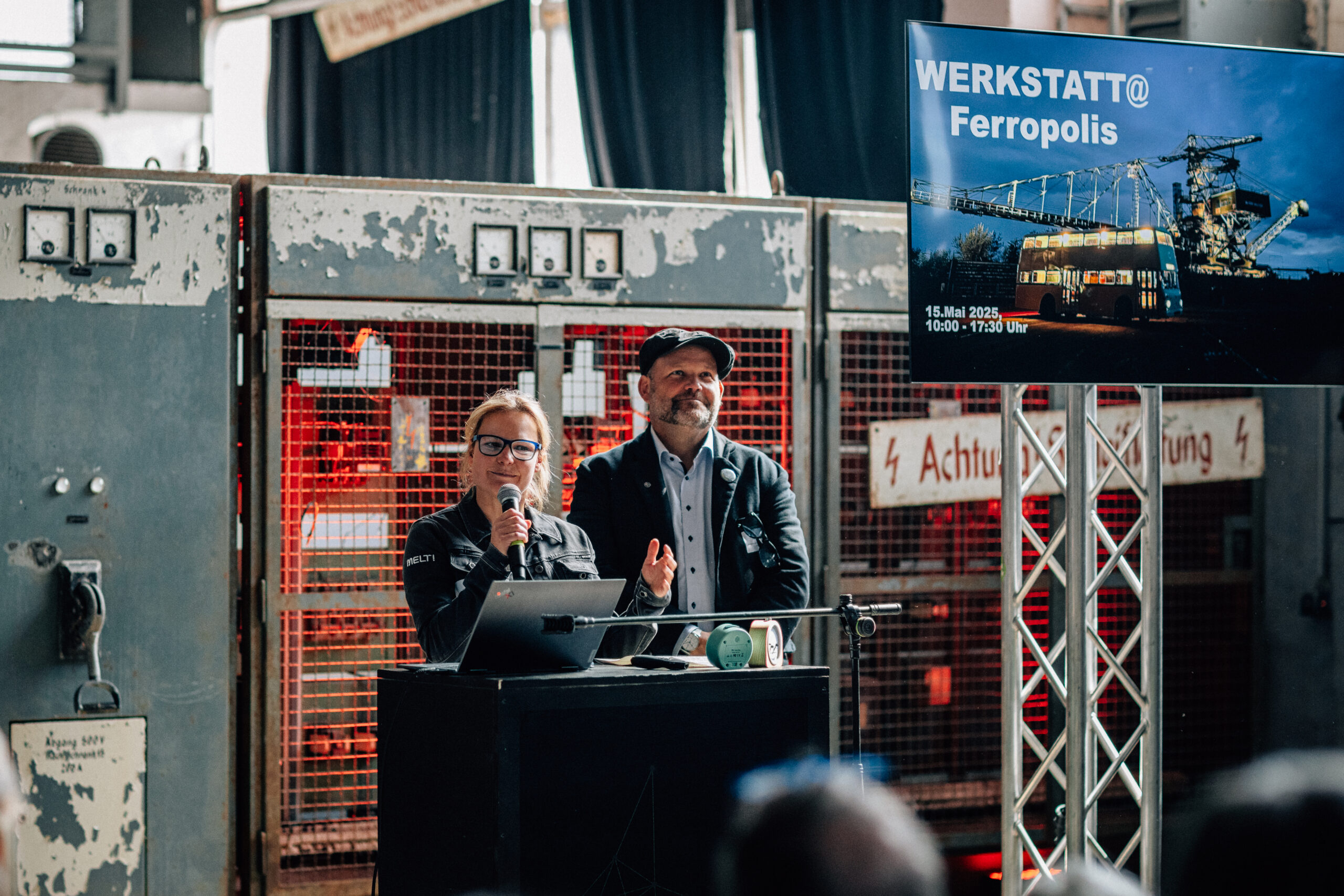 Janine Scharf von Ferropolis und Dr.-Ing. Thomas Fischer vom Netzwerk Industriekultur Sachsen-Anhalt (NIK) begrüßen die Gäste der Werkstatt 2025. | © Hartmut Bösener